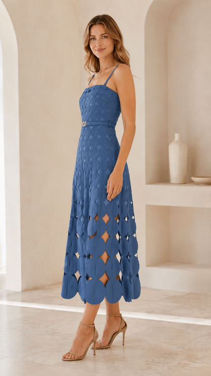 Woman wearing dusty blue spaghetti strap midi dress with belted waist and cutout hem