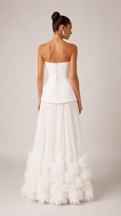 Back view of ivory strapless maxi gown with lace-up back and textured ruffle hem