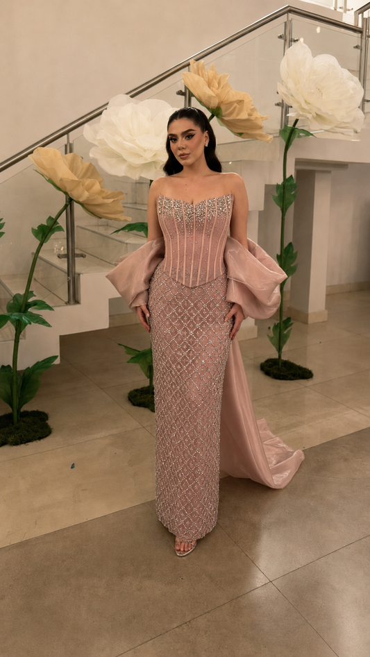Blush beaded strapless column evening gown with oversized draped sleeves and train front view