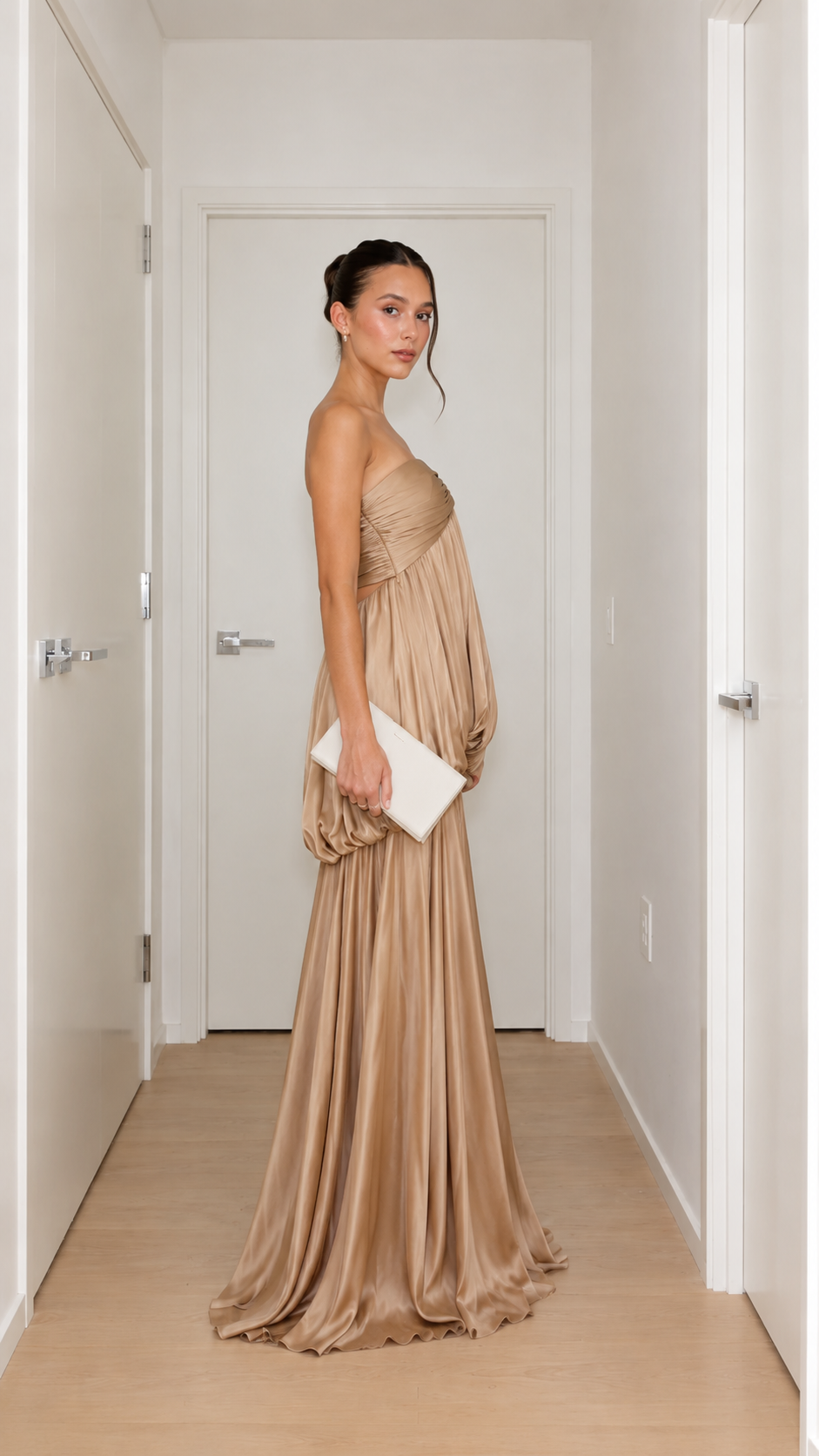 Side view of champagne strapless satin-like maxi gown with flowing skirt