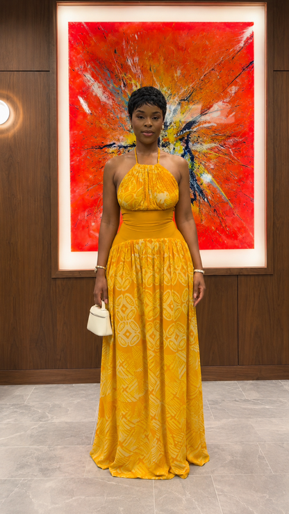 Woman wearing mustard halter neck textured maxi dress with flowing skirt front view