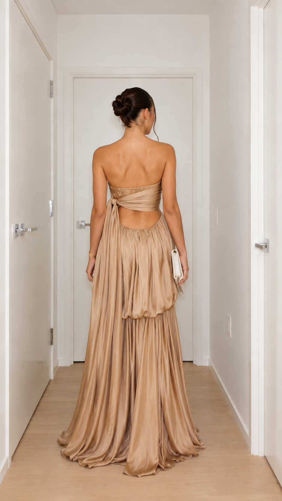 Back view of champagne strapless gown with open back and tie detail