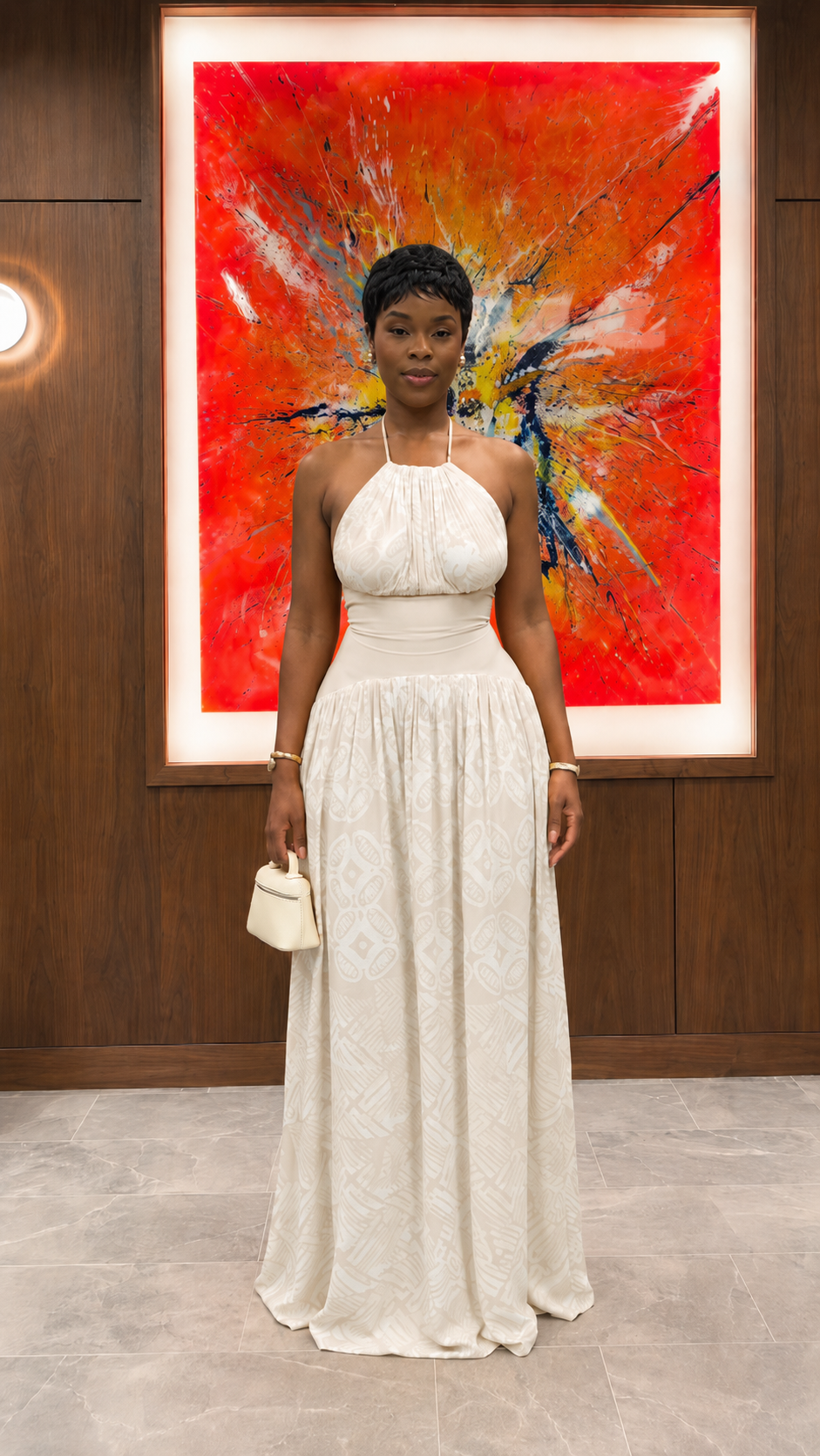 Woman wearing ivory halter neck textured maxi dress with gathered bodice front view