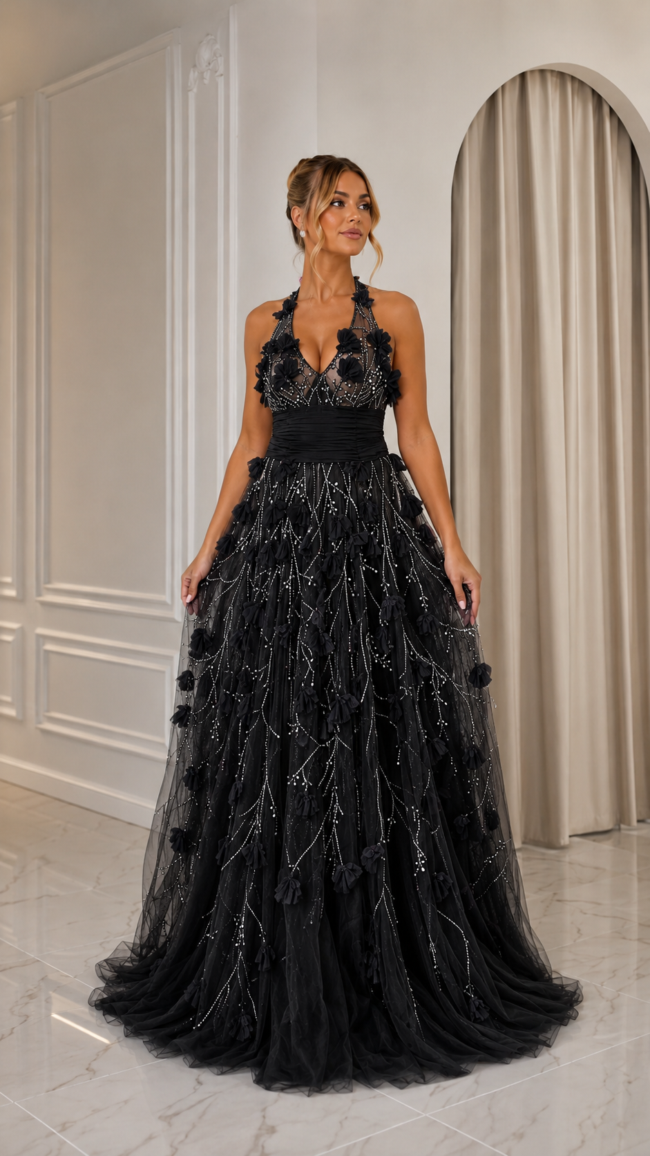 Front view of black halter tulle gown with textured floral embellishment