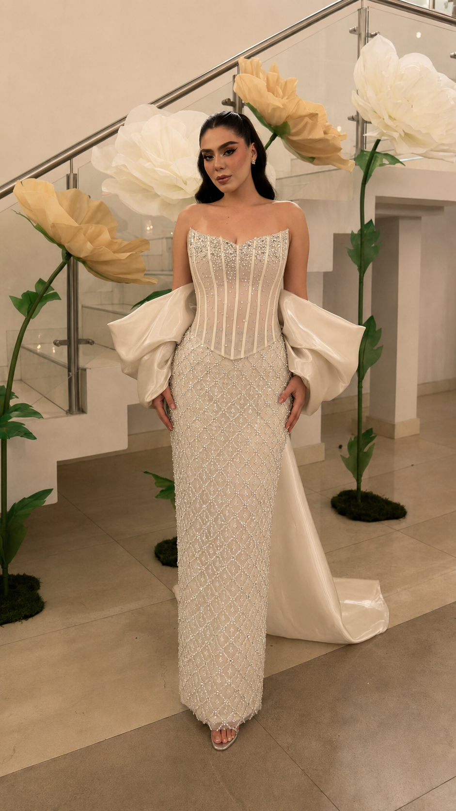 Ivory beaded column formal gown with structured bodice and satin-like sleeve drape