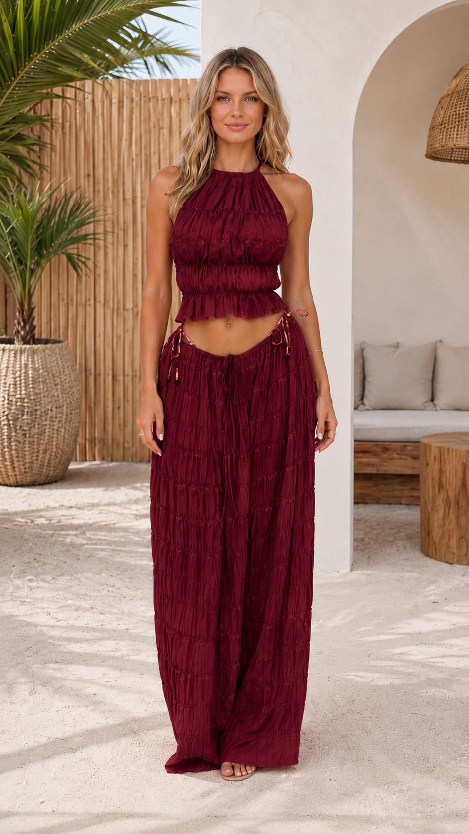Front view of burgundy textured halter crop top and wide-leg pants matching set