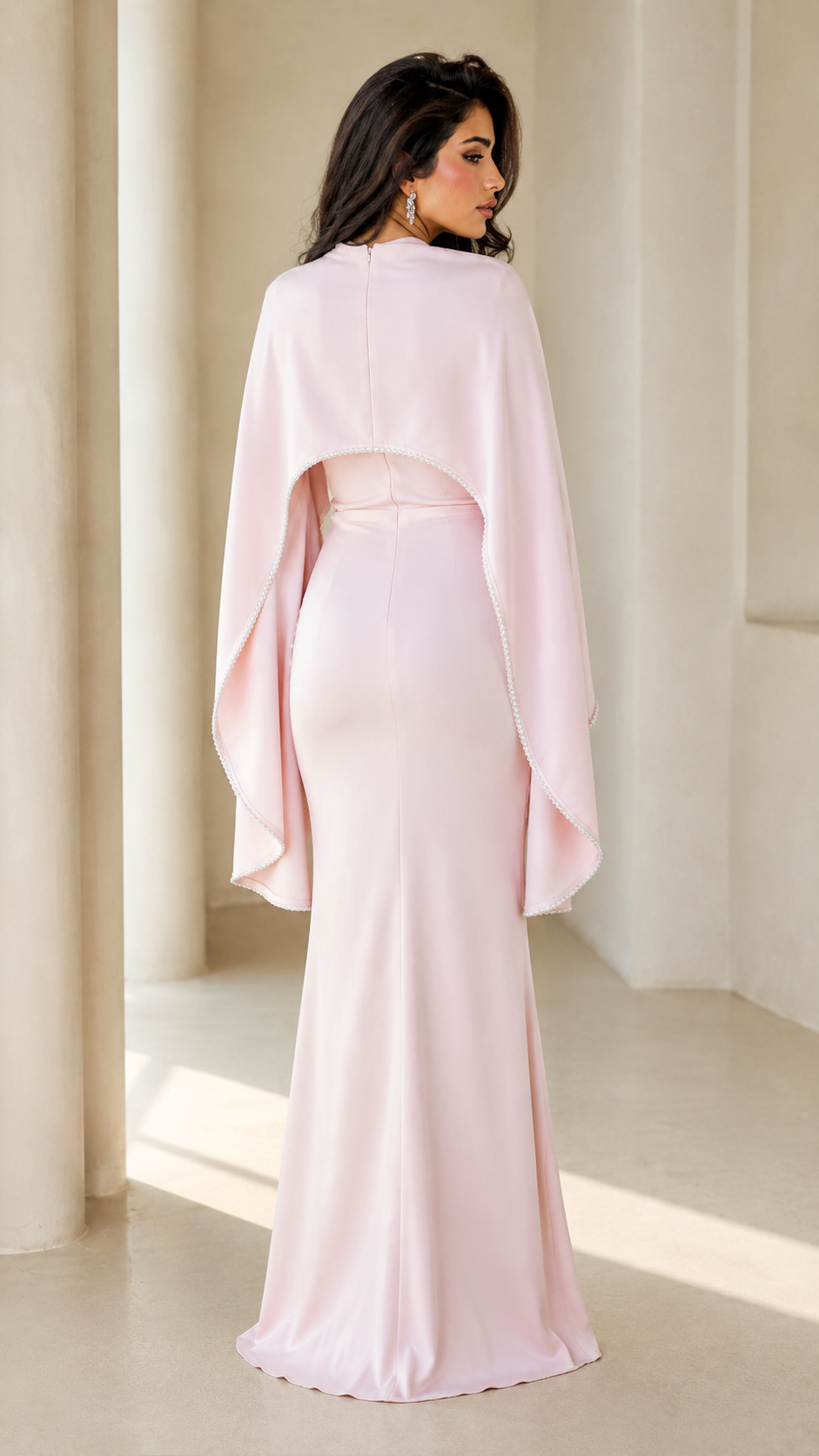 Back view of blush pink floor-length evening gown with cape overlay