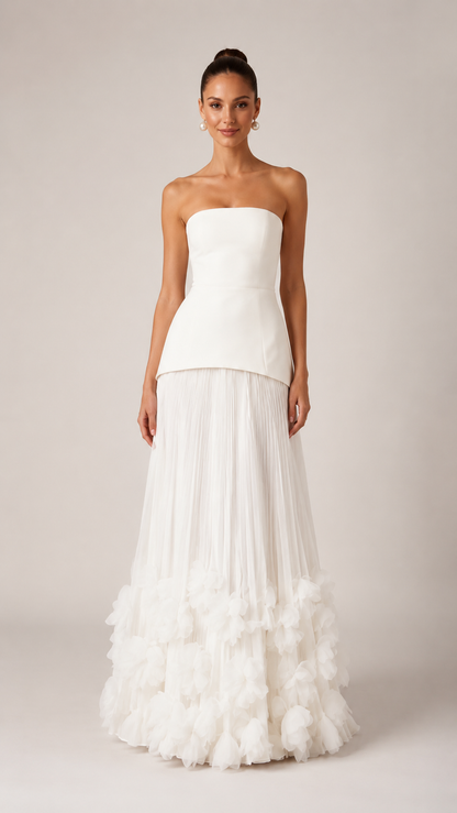 Front view of ivory strapless maxi gown with smooth bodice and full pleated skirt