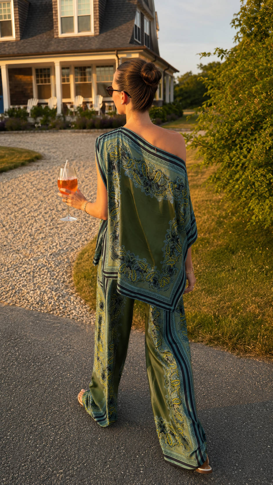Back view of olive green one-shoulder poncho top and matching printed wide leg pants