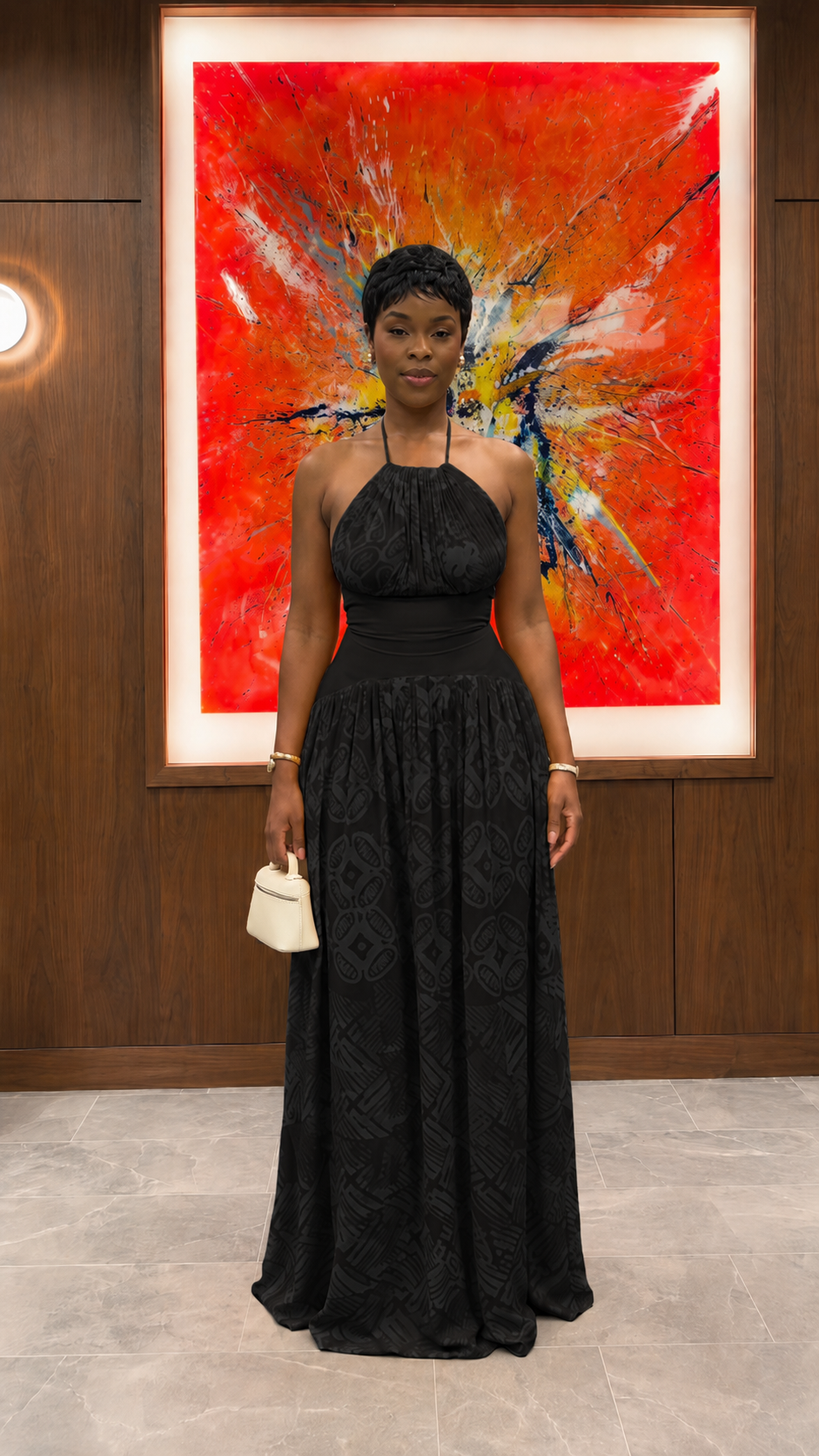 Woman wearing black halter neck textured maxi dress with fitted waistband front view