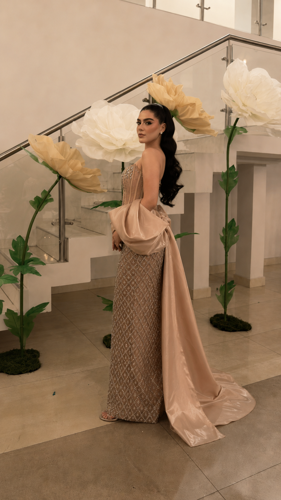 Side back view of champagne embellished column gown with flowing draped train