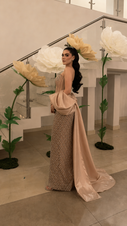 Side back view of champagne embellished column gown with flowing draped train