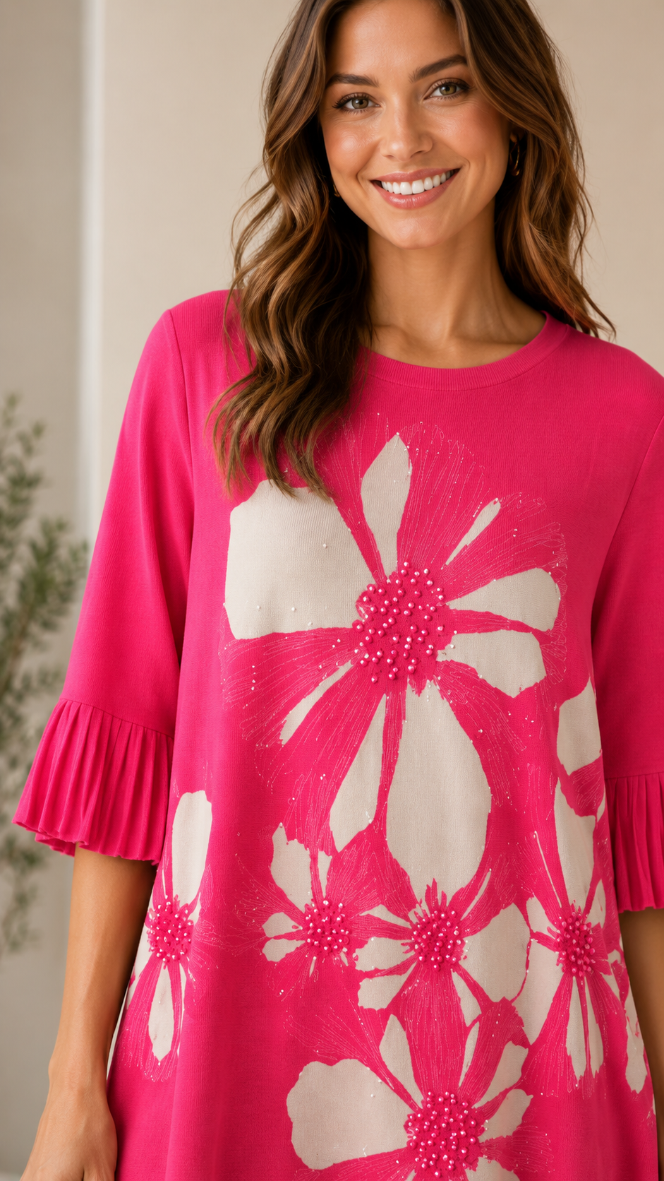 Close-up of hot pink floral dress showing round neckline, floral print, and pleated sleeve cuff