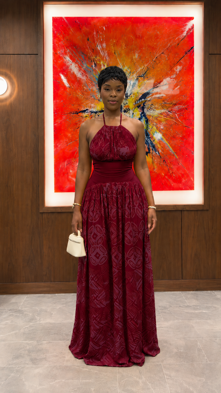Woman wearing burgundy halter neck textured maxi dress with flowing silhouette front view