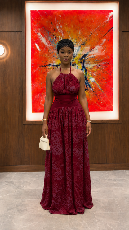 Woman wearing burgundy halter neck textured maxi dress with flowing silhouette front view