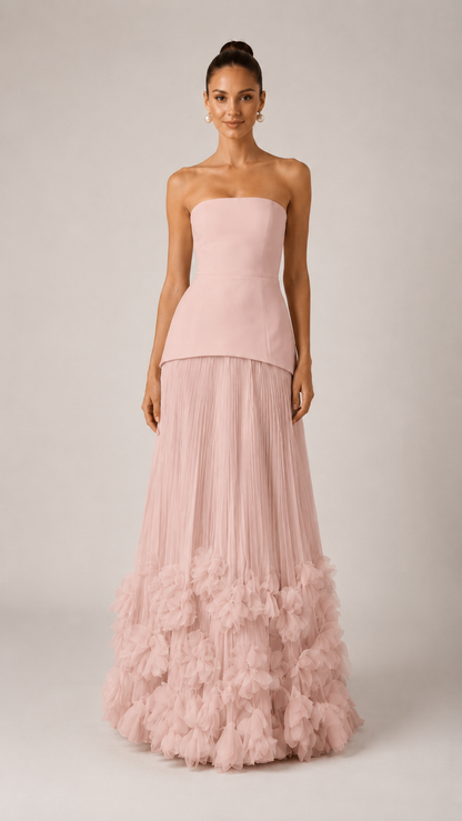 Front view of blush pink strapless maxi gown with pleated skirt and soft ruffle hem