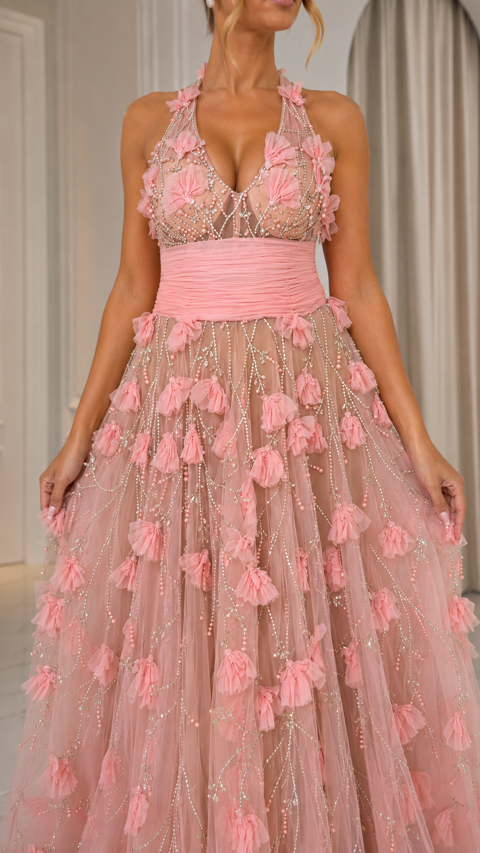 Close-up of blush pink bodice with halter neckline, floral appliqué, and ruched waist