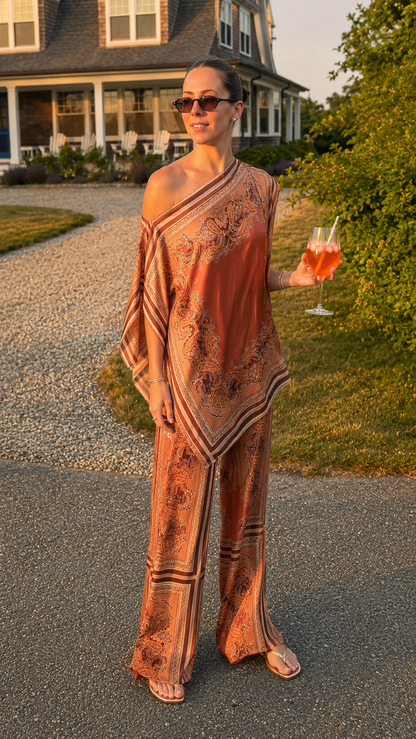 Model wearing rust printed one-shoulder top with matching wide leg pants front view