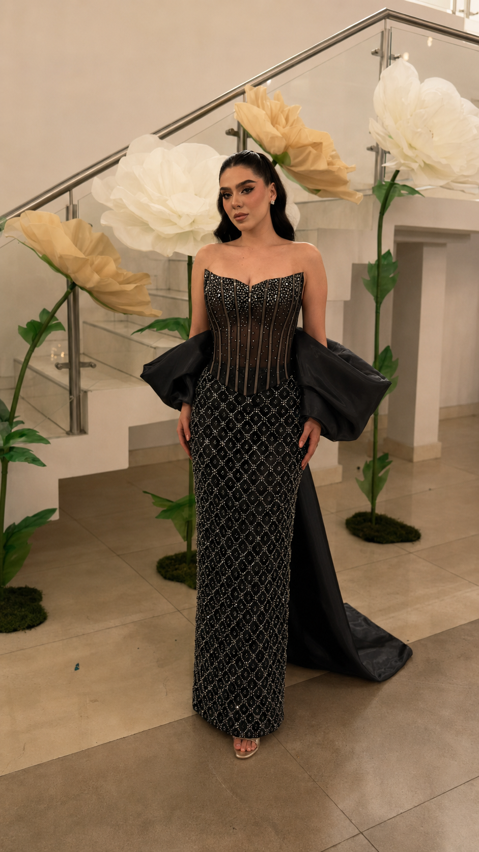 Black beaded strapless column gown with structured bodice and statement sleeve drape