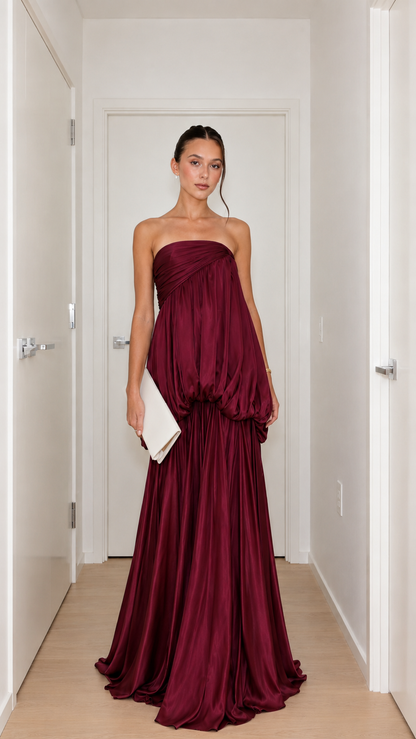 Front view of burgundy strapless draped bubble waist maxi gown